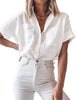 Front view of model wearing white short cuffed sleeves pockets button-up top