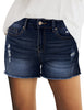 Front view of model wearing blue mid-waist raw hem distressed faded denim shorts