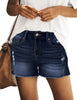 Model wearing blue mid-waist raw hem distressed faded denim shorts