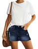 Front view of model wearing blue mid-waist raw hem distressed faded denim shorts