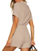 Back view of model wearing light mauve short sleeves button-down belted romper