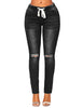 Front view of model wearing black drawstring-waist washout ripped skinny jeans