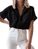 Front view of model wearing black short cuffed sleeves pockets button-up top