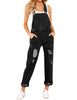 Model poses wearing black cuffed hem ripped bib denim overall jumpsuit