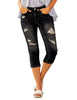 Front view of model wearing black below-knee cropped skinny denim jeans
