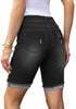 Back view of model wearing black plus size mid-waist ripped denim bermuda shorts.