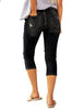 Back view of model wearing black below-knee cropped skinny denim jeans