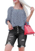 Front view of model wearing black frayed hem ripped button-up denim bermuda shorts