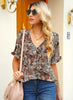 Front view of model wearing brown ruffle trim short sleeves floral V-neck button-down top