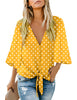 Front view of model wearing yellow polka dots V-neckline button-up tie-front top