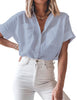 Front view of model wearing light blue short cuffed sleeves pockets button-up top