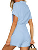 Back view of model wearing light blue short sleeves button-down belted romper