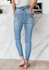 Back view of model wearing light blue high-waist acid wash belted denim skinny jeans