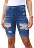 Front view of model wearing blue plus size mid-waist ripped denim bermuda shorts.