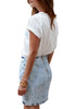 Angled back view of model wearing grey acid wash tulip ruched denim mini skirt