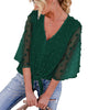 Front view of model wearing dark green 3/4 sleeves pompom tie-front top