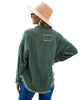 Back view of model wearing dark green drop shoulders contrast corduroy button-down jacket
