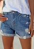 Angled shot of model wearing blue roll-over distressed denim shorts