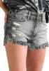 Angled shot of model wearing grey frayed raw hem distressed denim shorts