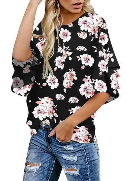 Angled side shot of model in black trumpet sleeves keyhole-back printed blouse