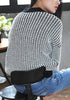 Back of girl in black and white knitted baseball jacket