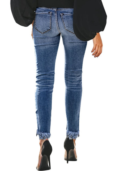 Back view of model wearing blue mid-waist raw hem  cropped ripped denim jeans