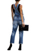 Back view of model wearing dark blue cropped raw hem ripped denim bib overall