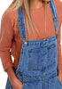 Close up shot of model wearing dark blue rolled hem shorts denim bib overall