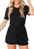 Front view of model wearing black crew neck overlay drawstring knit romper