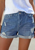 Front view of model wearing blue roll-over distressed denim shorts
