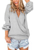 Front view of woman wearing light grey lantern sleeves surplice sweater