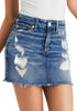 Front view of model wearing blue frayed raw hem ripped denim mini skirt.