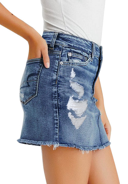 Side view of model wearing blue frayed raw hem ripped denim mini skirt