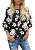 Model poses wearing black trumpet sleeves keyhole-back printed blouse