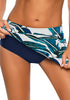 Model poses wearing blue zipper-pocket waistband leaves-print skirted bikini bottom