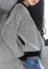 Right side of girl in black and white knitted baseball jacket