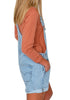 Side view of model wearing light blue rolled hem shorts denim bib overall