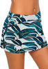 Side view of model wearing blue zipper-pocket waistband leaves-print skirted bikini bottom