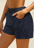Side view of model wearing navy elastic-waist side pockets lace-up board shorts