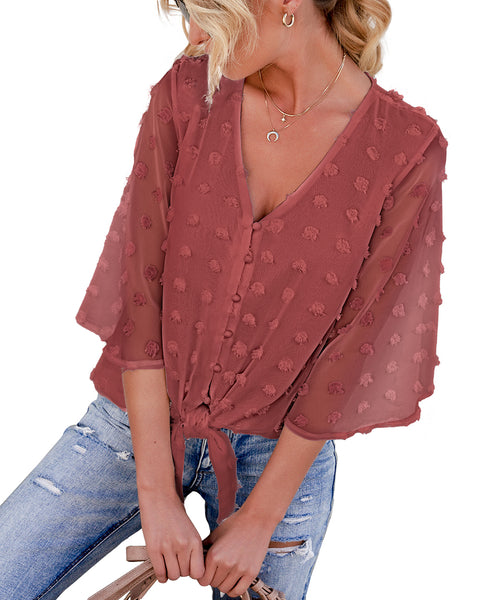 Model poses wearing blush 3/4 sleeves pompom tie-front top