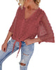 Angled view of model wearing blush 3/4 sleeves pompom tie-front top