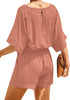 Back view of model wearing blush V-neckline keyhole-back loose belted romper