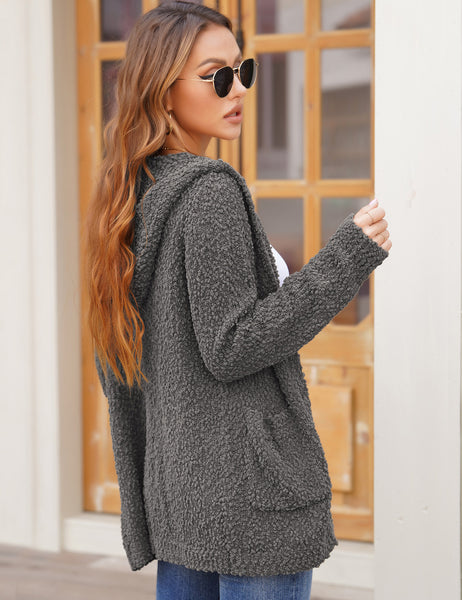 Side view of model wearing dark grey button down melange waffle knit hooded cardigan