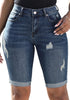 Front view of model wearing dark blue mid-waist cuffed hem distressed denim bermuda shorts