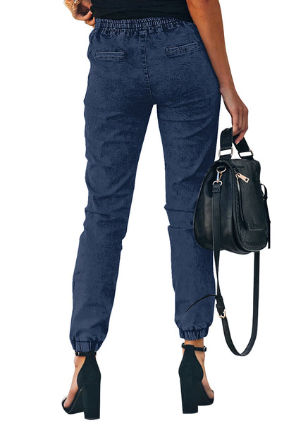 Back view of model wearing deep blue elastic-waist welt pockets denim jogger pants