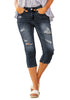Model poses wearing dark blue below knee cropped skinny denim jeans