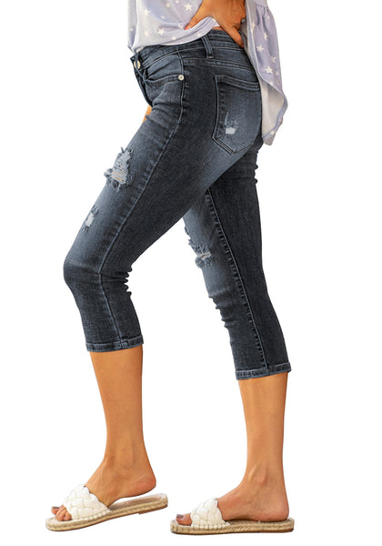 Side view of model wearing dark blue below knee cropped skinny denim jeans