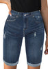 Model wearing dark blue mid-waist cuffed hem distressed denim bermuda shorts