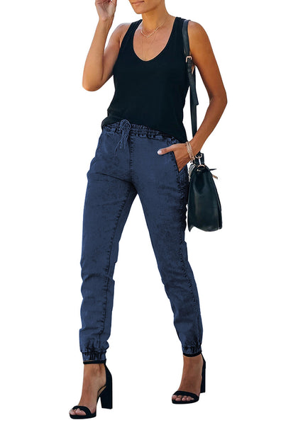 Angled shot of model wearing deep blue elastic-waist welt pockets denim jogger pants