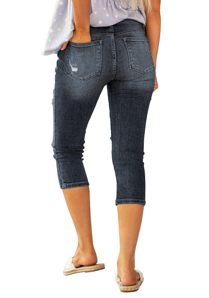 Back view of model wearing dark blue below knee cropped skinny denim jeans